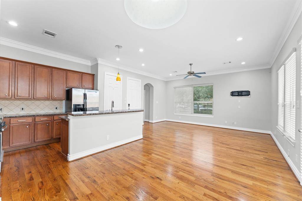 Bright and spacious open-concept kitchen and living area with hardwood floors, stainless steel appliances, and ample natural light.