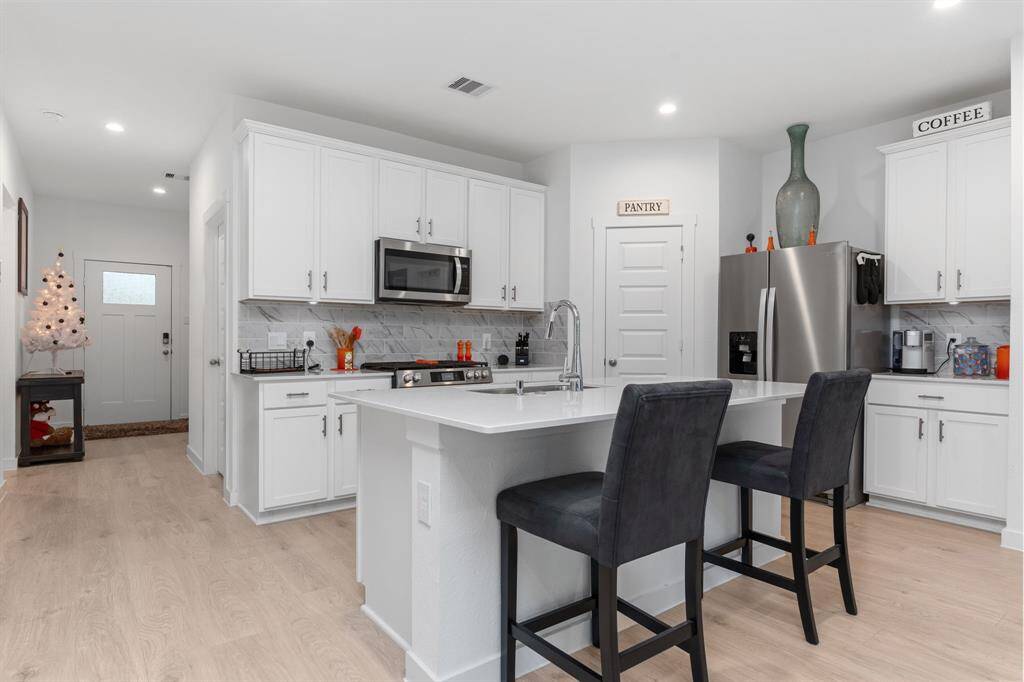 Kitchen featuring ample cabinetry, kitchen island and stainless steel appliances.