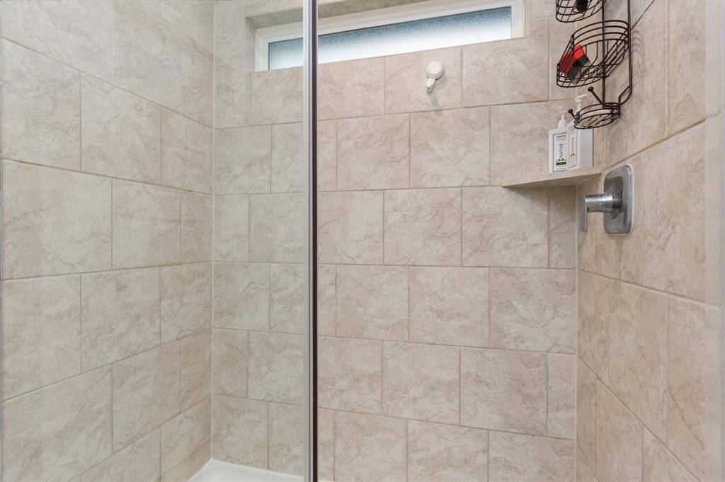 Primary en-suite bath with dual vanity sinks and standing shower.
