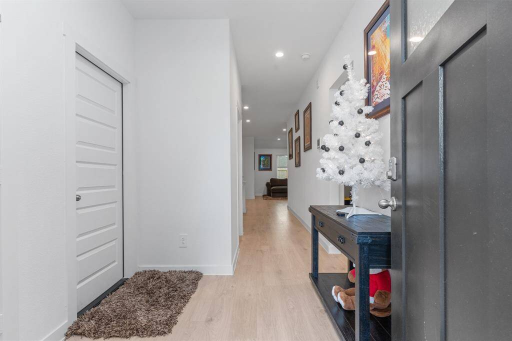 Foyer leading to the living room, garage (door on the right) and bedroom 1 (on the left)