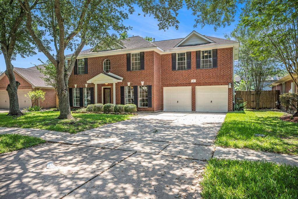 This two-story brick home has timeless curb appeal with a clean, classic look. It features a spacious driveway, two-car garage, and a charming front porch.
