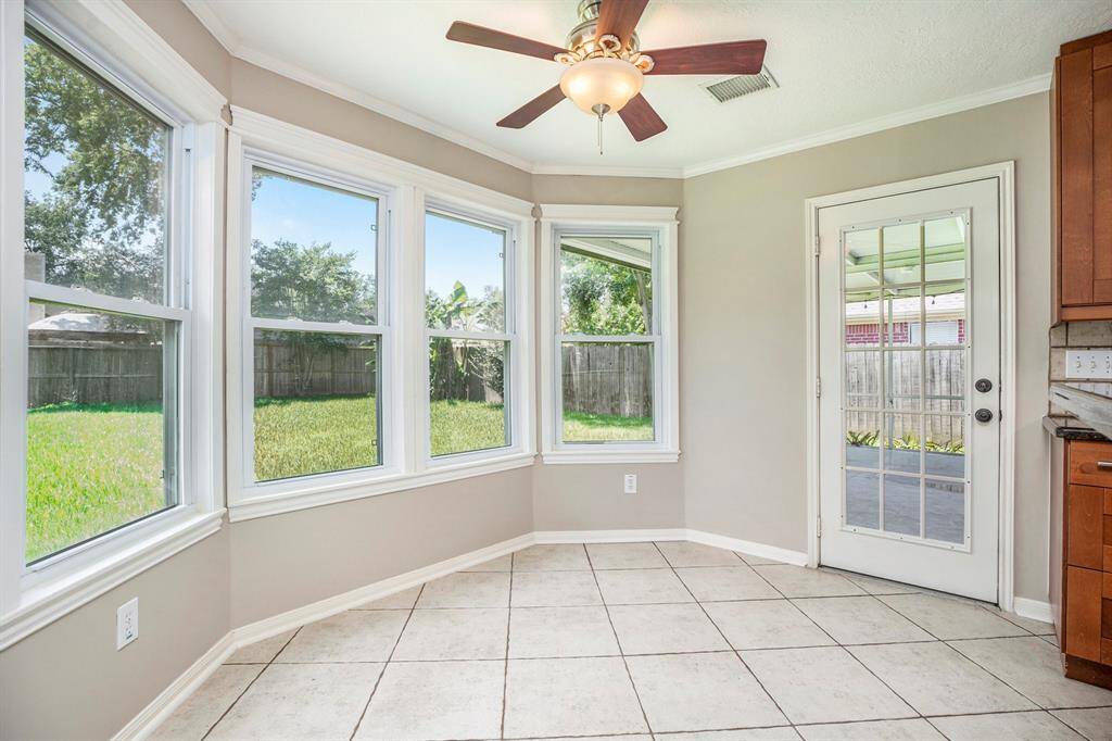 The breakfast area is filled with natural light from a wall of windows overlooking the backyard. It’s open to both the kitchen and living room, making it a bright and connected space for everyday meals.