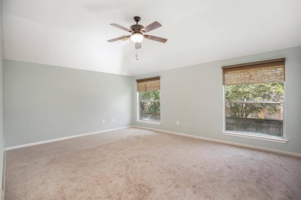 The upstairs game room offers plenty of space to spread out, with soft carpet, neutral tones, and lots of natural light—perfect for a media room, playroom, or second living area.