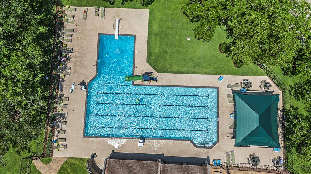 The community pool is just a short distance from the home and features lap lanes, a diving board, a water slide, and plenty of lounge space—perfect for relaxing or summer fun.