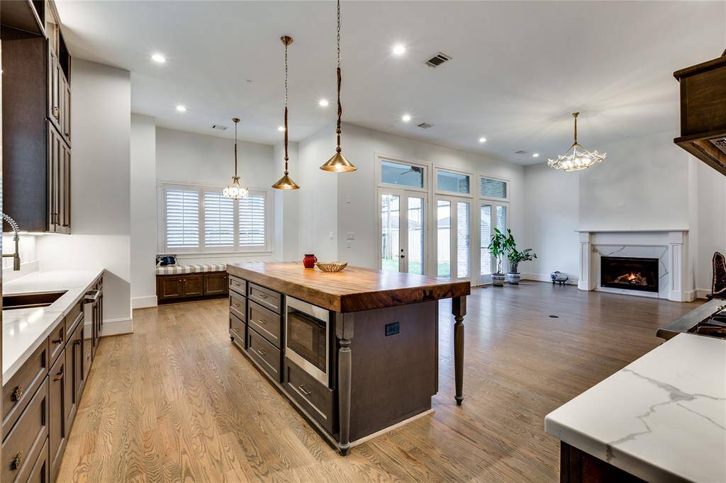 at the door of dirty kitchen looking into kitchen and family room, 100% brass lighting over kitchen island