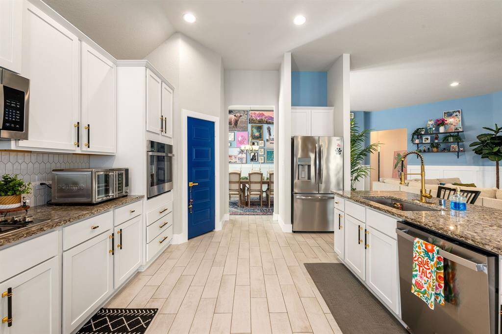 This stunning kitchen displays such a beautiful white stained cabinets, custom neutral paint, granite countertops, light modern backsplash, and SS appliances, oversized kitchen island with extra storage, breakfast bar, recessed lighting, high ceilings and walk in pantry.
