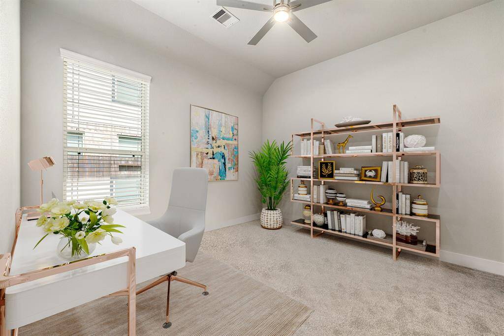 Secondary bedroom features plush carpet, custom paint, dark stained ceiling fan with lighting and a large window with privacy blinds. *Virtually Staged