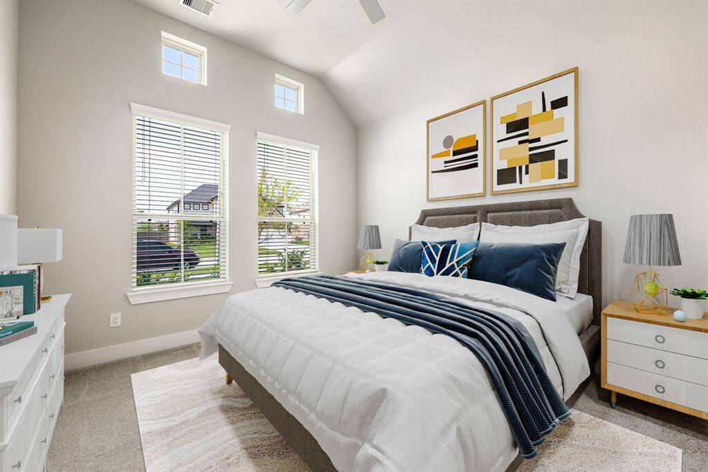 Secondary bedroom features plush carpet, custom paint, dark stained ceiling fan with lighting and a large window with privacy blinds. *Virtually Staged