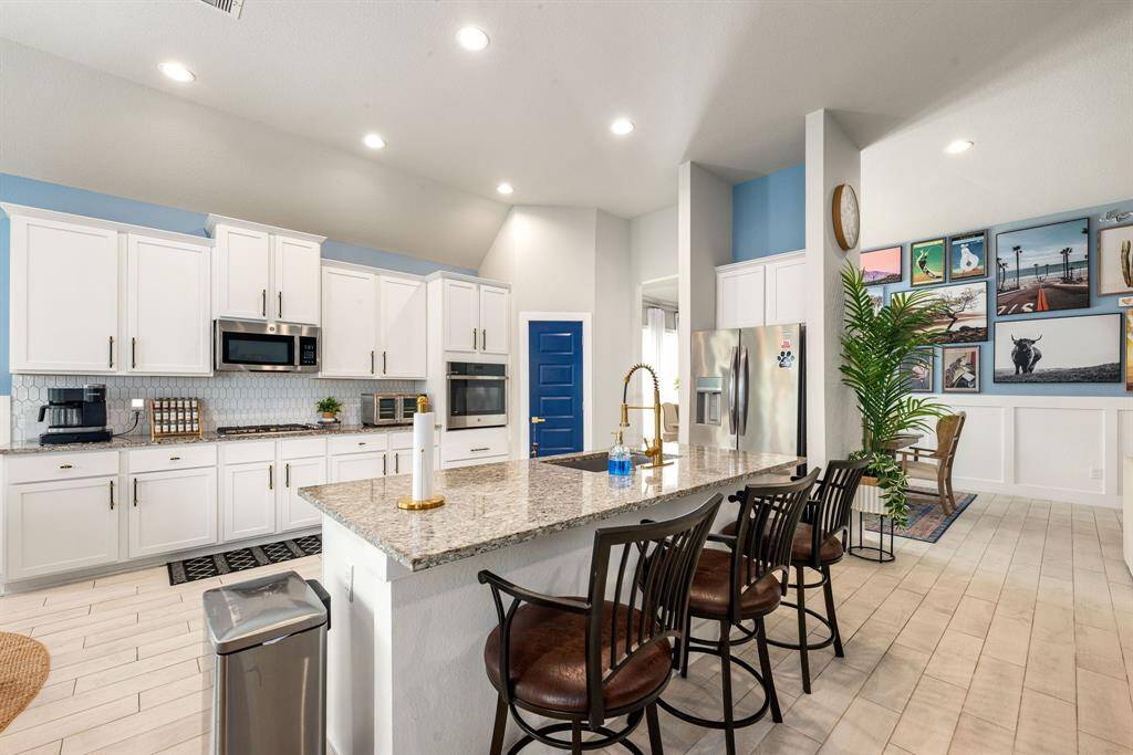 This kitchen is by far any chef’s dream! This spacious kitchen features high ceilings, white stained wood cabinets, granite countertops, SS appliances, modern tile backsplash, recessed lighting, granite kitchen island with double sink and space for breakfast bar and a walk-in pantry all overlooking your huge family room.
