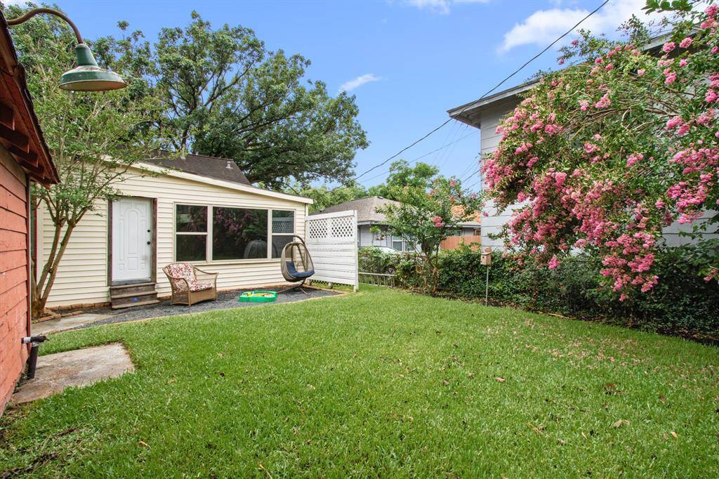 A gravel patio area at the rear of the home provides space for lounging furniture and views to the lush backyard.