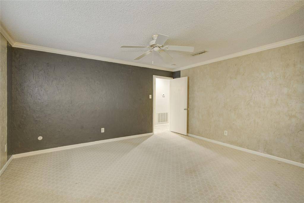 The view of the primary bedroom looking out to the hall shows accent wall.