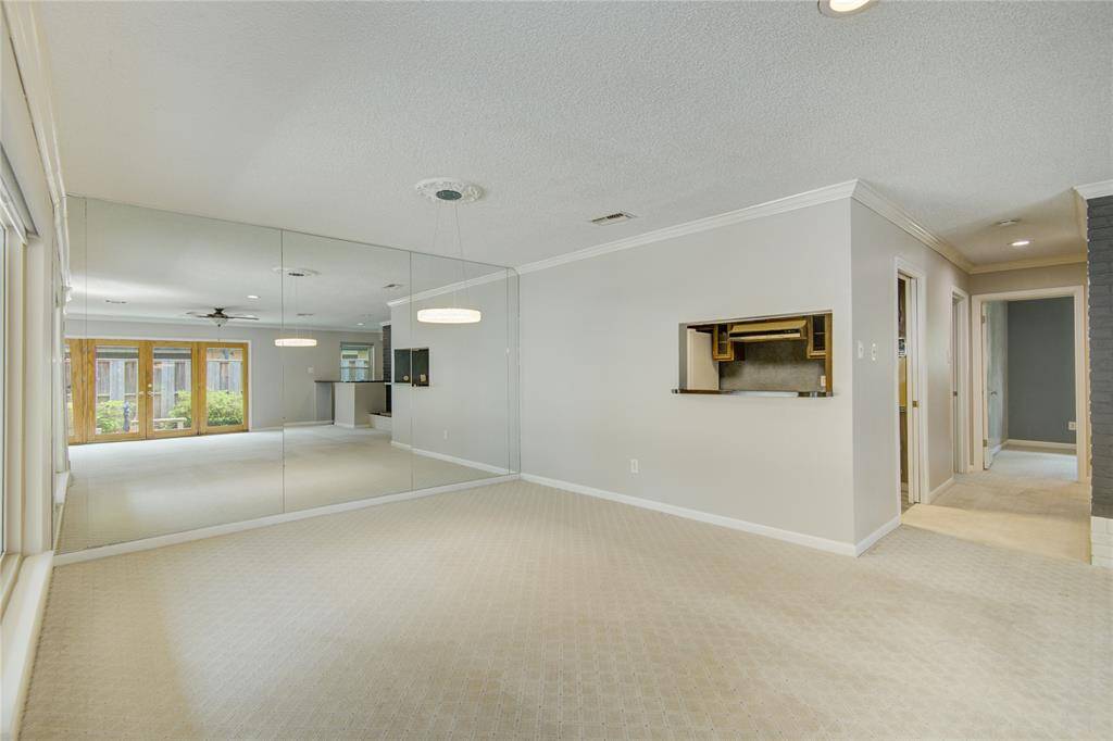 The dining room features a mirrored accent wall that enhances the natural light and adds a sense of spaciousness