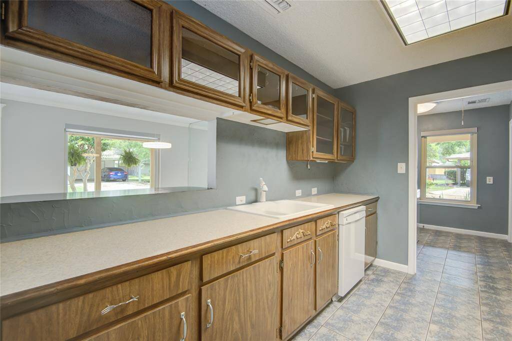 The kitchen offers ample counter space and a convenient pass-through opening to the dining room for easy entertaining.