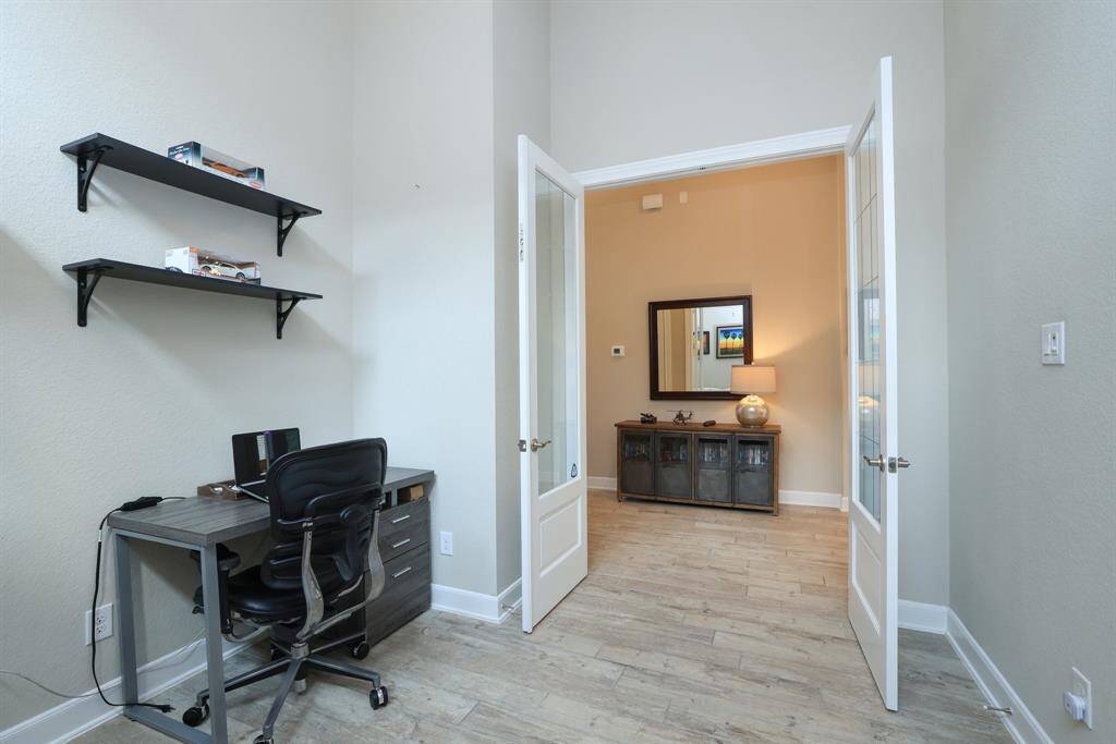 Perfect for dual-purpose use, this flexible space features easy-care wood-like tile flooring and soaring high ceilings, offering both functionality and style to fit your lifestyle.