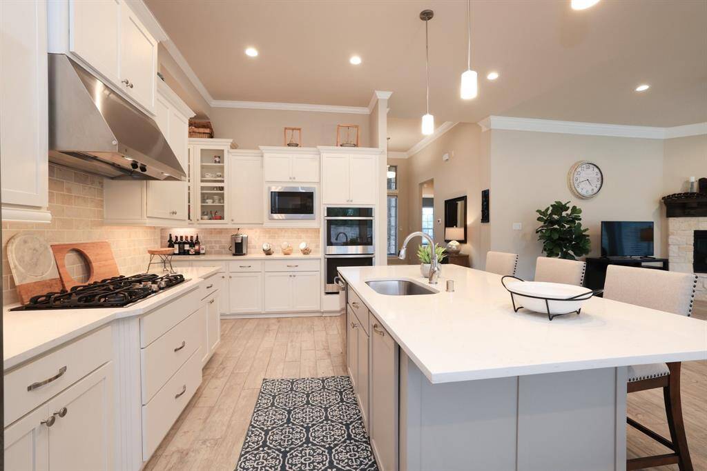 Enjoy the convenience of double ovens and a built-in microwave, with a back counter area ideal for creating a beverage center or coffee bar. Ample counter space and cabinet storage throughout the kitchen will be truly appreciated for both everyday use and entertaining.