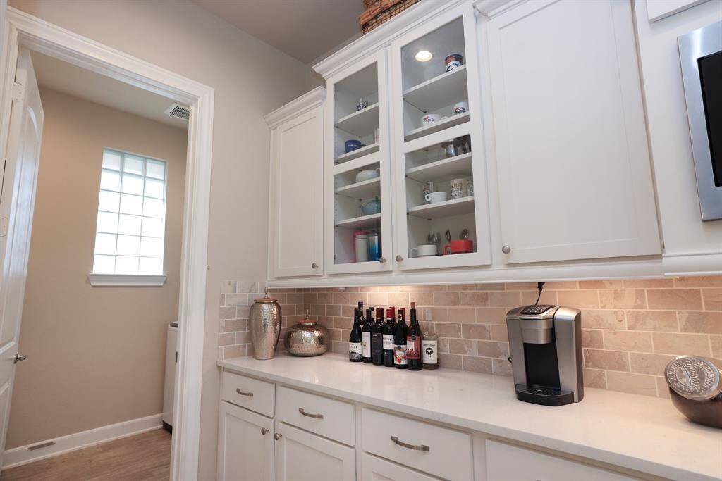 The perfect spot for your custom beverage center or coffee bar, this area offers both function and flexibility. Just steps away, a doorway leads to your indoor utility room, which features a window that brings in natural light to brighten the space.