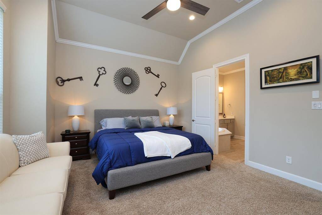 The primary bedroom and ensuite bathroom offer a peaceful retreat, featuring a stylish ceiling design, neutral paint tones, and a well-planned layout that combines comfort and functionality.