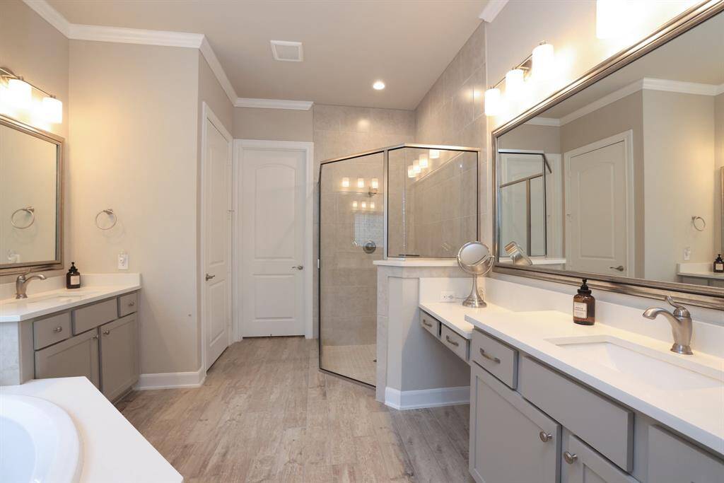 Indulge in luxury in your primary bathroom, featuring modern countertops, two drop-in sinks, framed mirrors, and stylish cabinet hardware.  Stay organized with good storage, while enjoying privacy with a water closet.