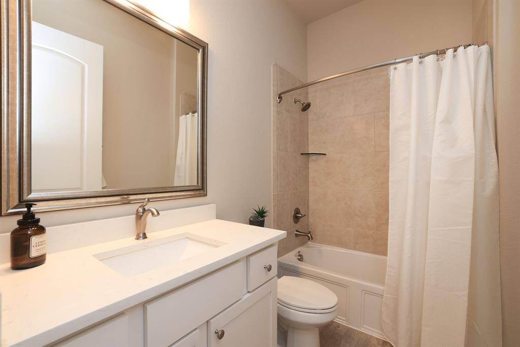 1 of 3 full bathrooms features a convenient tub and shower combination, catering to the needs of the household with both functionality and comfort.