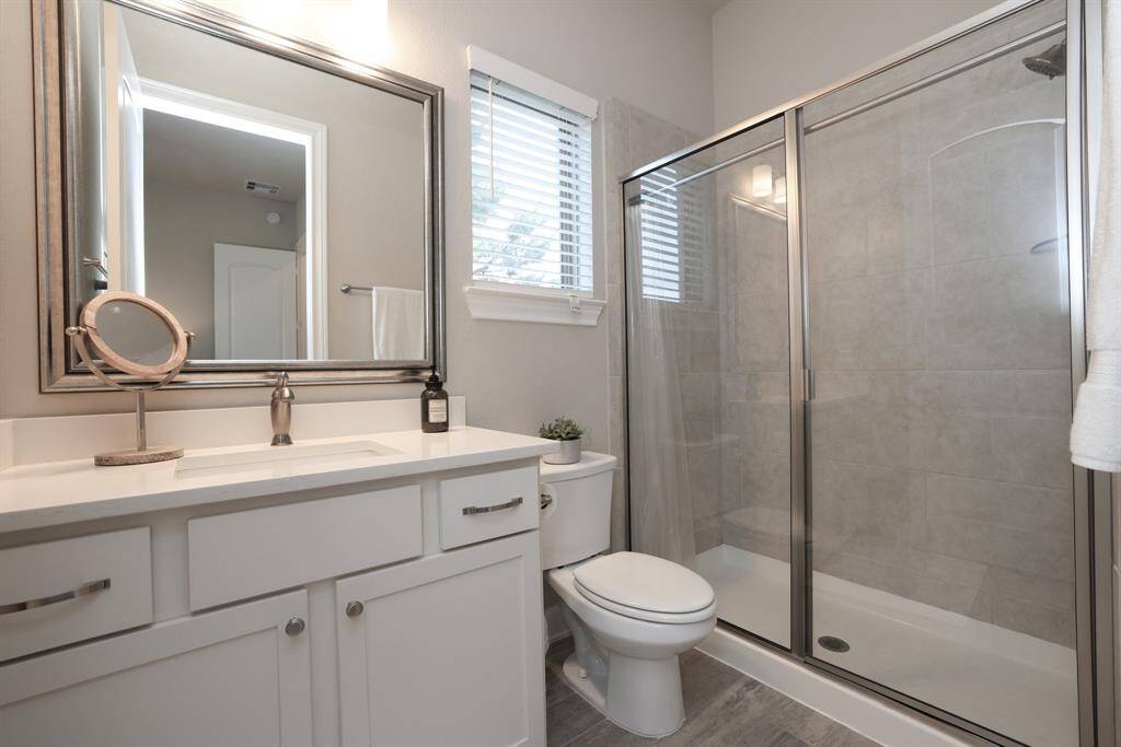 This home offers three full bathrooms, thoughtfully designed to serve both your family and guests. Each features framed mirrors, light cabinetry, and easy-care wood-like tile flooring, combining functionality with tasteful design.