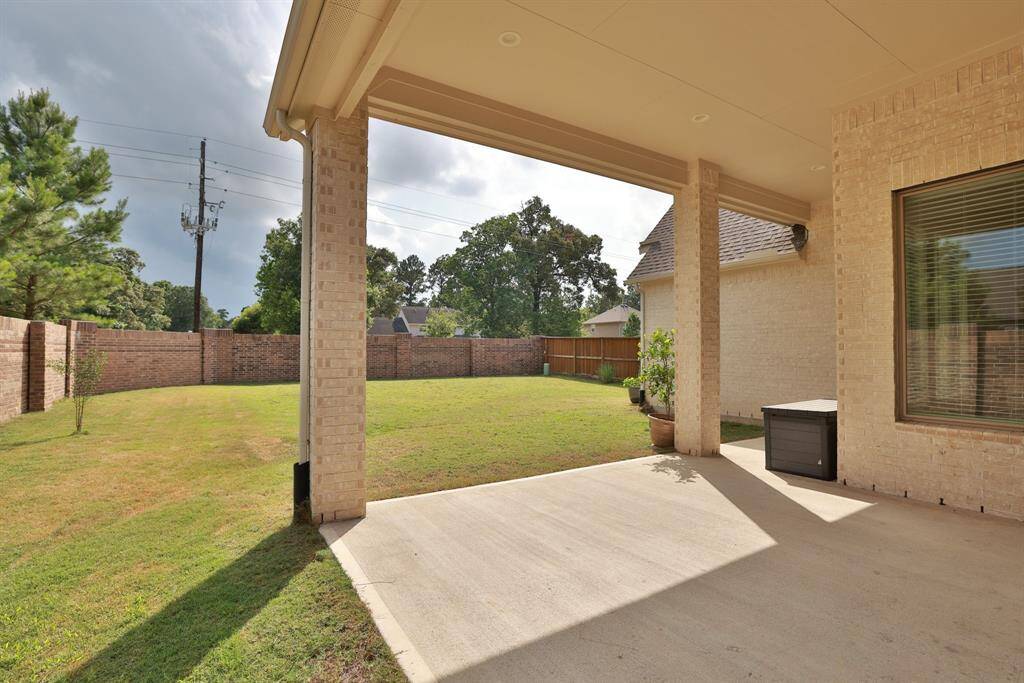 Your covered back porch offers the perfect setting for outdoor living, ideal for relaxing or entertaining. Enjoy added privacy with easy-care brick fencing on two sides, enhancing both function and curb appeal.