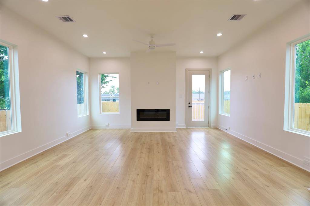 The four windows keep the living room bright and airy, while the fireplace adds a touch of warmth, creating a cozy and inviting atmosphere.