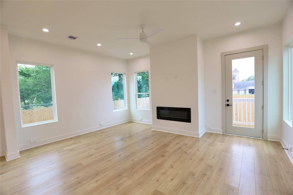 Your living room is complete with a remote-controlled fan, and to the right of the fireplace, you'll find a patio door leading to your spacious backyard