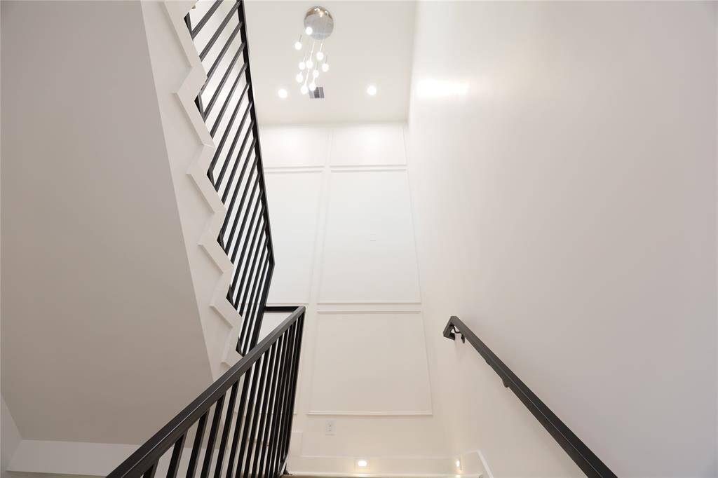 35-foot floor-to-ceiling accent wall makes a dramatic statement, paired with a radiant 9FT chandelier that fills the space with light as you ascend. The staircase showcases exquisite craftsmanship, with step-by-step carpentry details that add timeless charm and elegance.