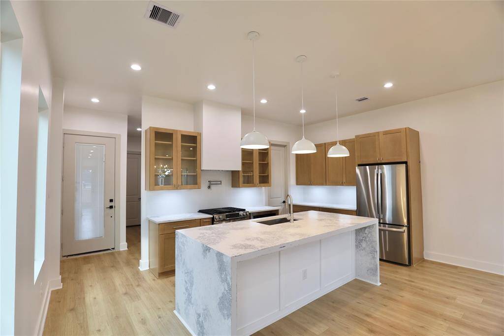This bright and airy kitchen is adorned with sleek, modern finishes, under-cabinet lighting, and thoughtful upgrades throughout. The walk-in pantry offers a well-designed space for ultimate convenience.