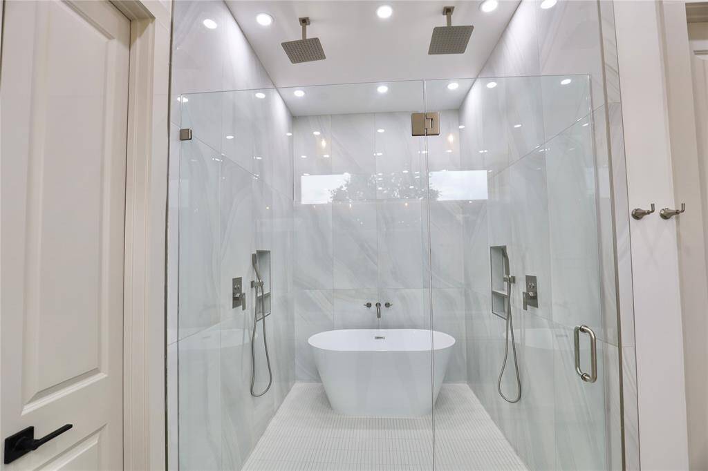 Recessed ceiling lights enhance the spa-like ambiance, creating a tranquil atmosphere while showering.