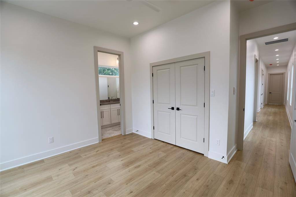Third Bedroom, french warm toned closet doors, notice the vast distance to the primary suite offering privacy.