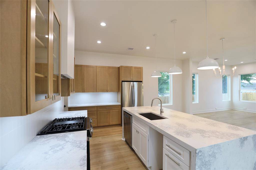 The striking island features a dual trash bin pull-out, with a drawer above designed to store trash bags for easy disposal. The open space is sized for your wine fridge—this kitchen has it all.