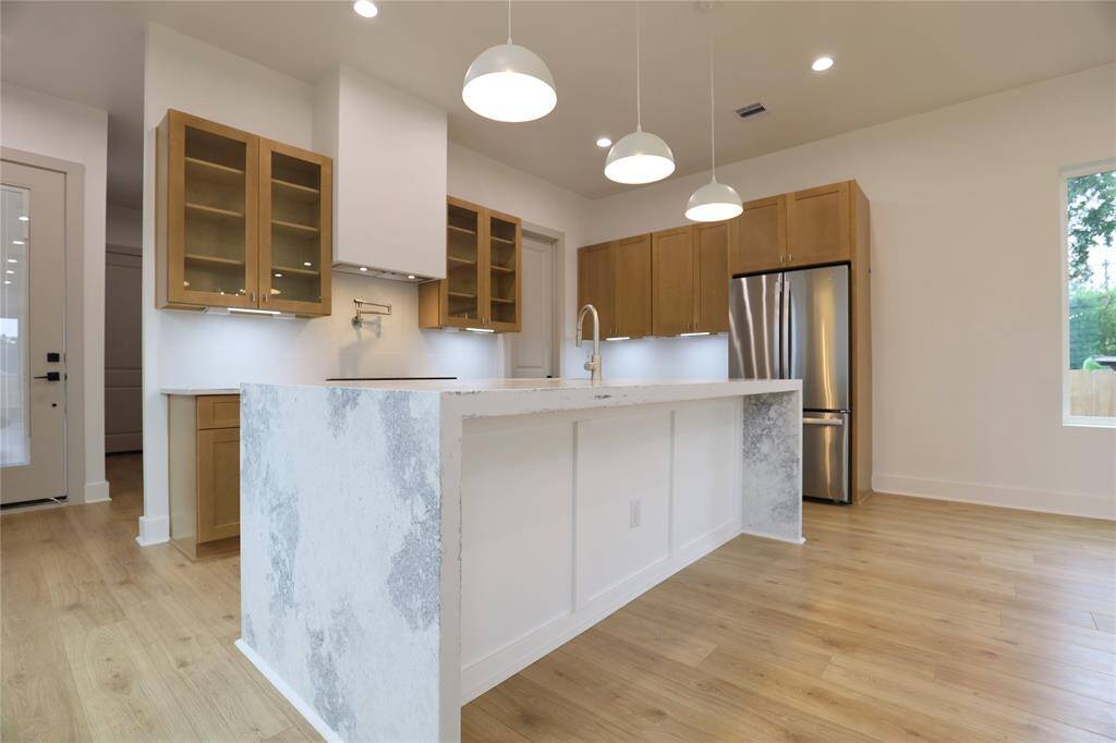 The oversized island makes hosting a breeze, beautifully complemented by attractive soft-close cabinetry that adds a touch of elegance and charm to the space.