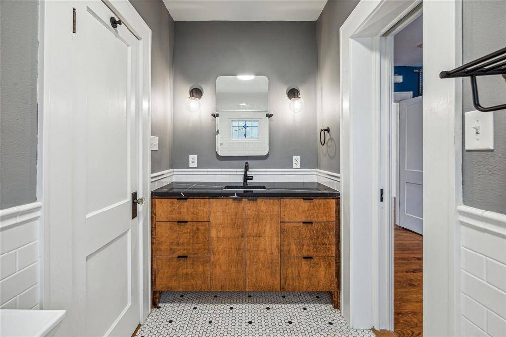 The updated Bath showcases timeless tile and an elegant backsplash, complemented by a classic period door knob and modernized lighting.