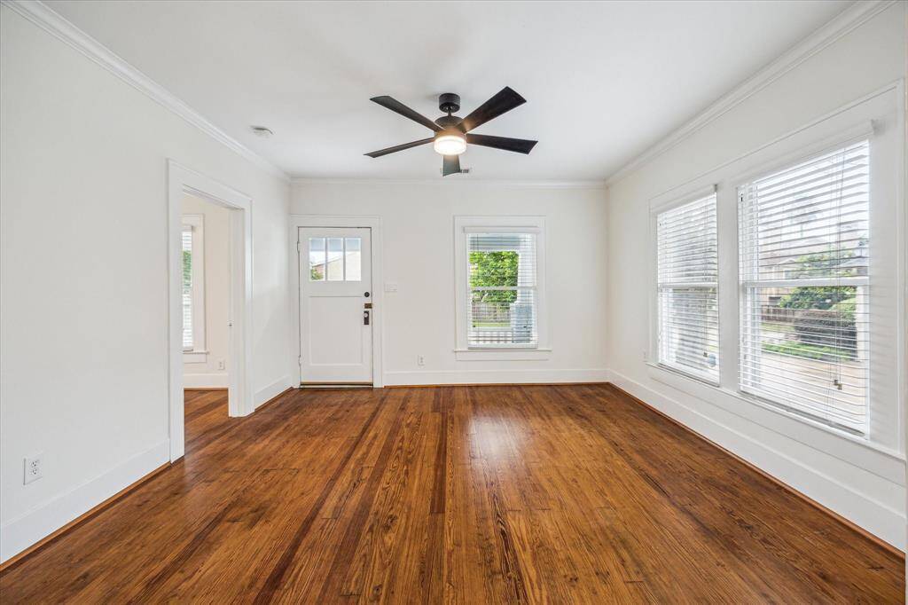 Step into this Charming Heights bungalow, where exquisite craftsmanship meets modern elegance. View of Living Room, featuring gleaming hardwood floors and ample natural light, creating a bright, inviting space that highlights the home's beautiful architectural details.