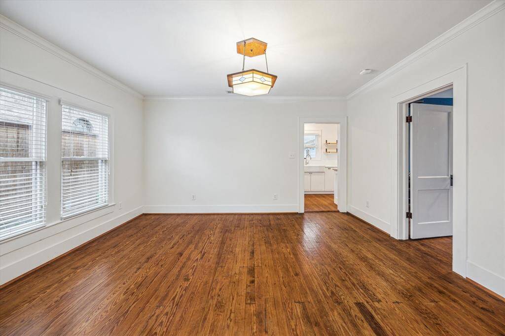 The expansive Dining Room features beautiful hardwood floors and an abundance of natural light, which highlights the stunning period light fixture that adds a touch of timeless elegance.
