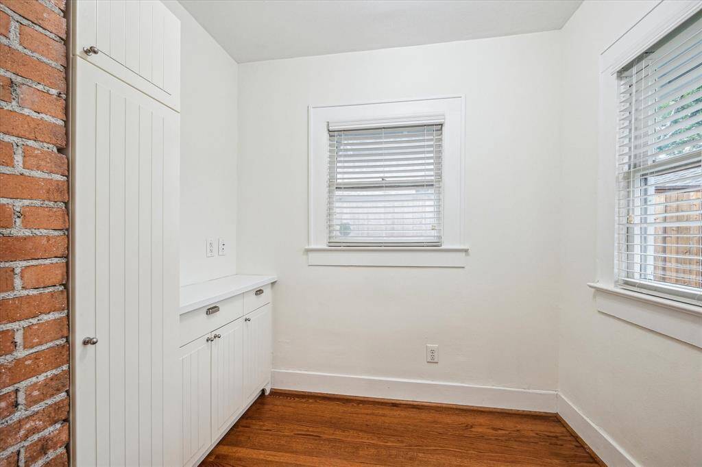The versatile extra room off the Kitchen provides ample storage and is graced with exposed brick and abundant natural light. It's perfect for use as a sunroom, office, study, or any other purpose you envision.