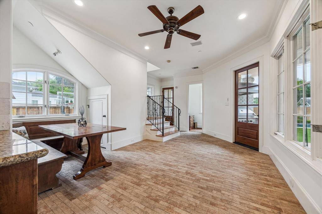 This spacious breakfast room features a generous layout with plenty of natural light streaming through large windows. Tucked into a cozy nook beneath a sloped ceiling, maximizing space and functionality. The room offers easy access to both the kitchen and backyard, making it a convenient and comfortable dining area for daily use.