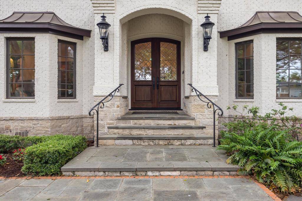 A grand double-door entrance sets the tone for the refined interiors beyond, while the beautifully landscaped front yard and expansive lawn offer incredible curb appeal.