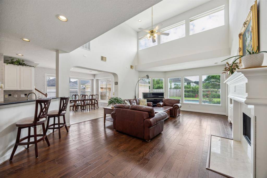 The ambient glow from the fireplace adds a cozy charm, while the flow to adjacent spaces makes entertaining effortless. This is a room that adapts gracefully to every occasion, offering both elegance and ease in one stunning setting.