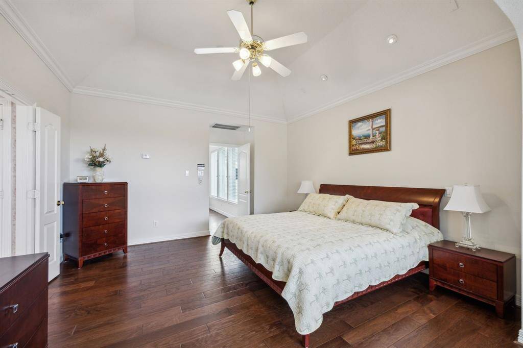 The spacious primary retreat is a true sanctuary, featuring warm wood floors that bring a sense of comfort and elegance to the space.