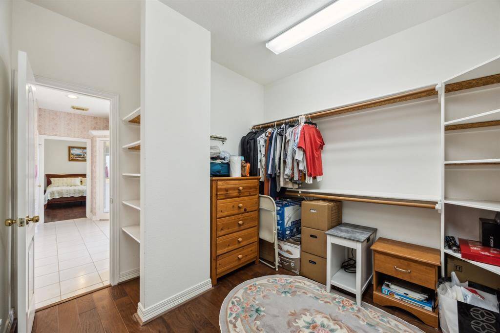 The expansive primary closet offers exceptional storage and organization with its generous layout and beautiful wood flooring that seamlessly flows from the bedroom. Thoughtfully designed to accommodate both wardrobe and accessories, this walk-in space combines functionality with a touch of luxury.