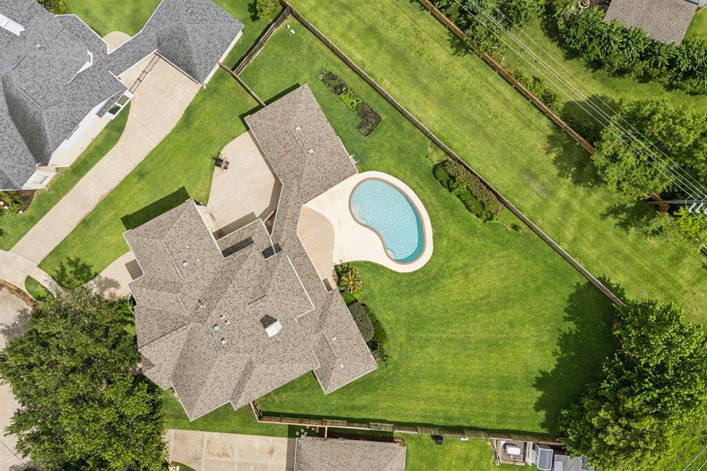 From a stunning aerial perspective, the sparkling pool becomes the centerpiece of the backyard oasis, surrounded by lush landscaping and inviting outdoor living spaces. This bird’s-eye view highlights the perfect blend of luxury and tranquility, showcasing an ideal setting for relaxation and entertaining under the open sky.