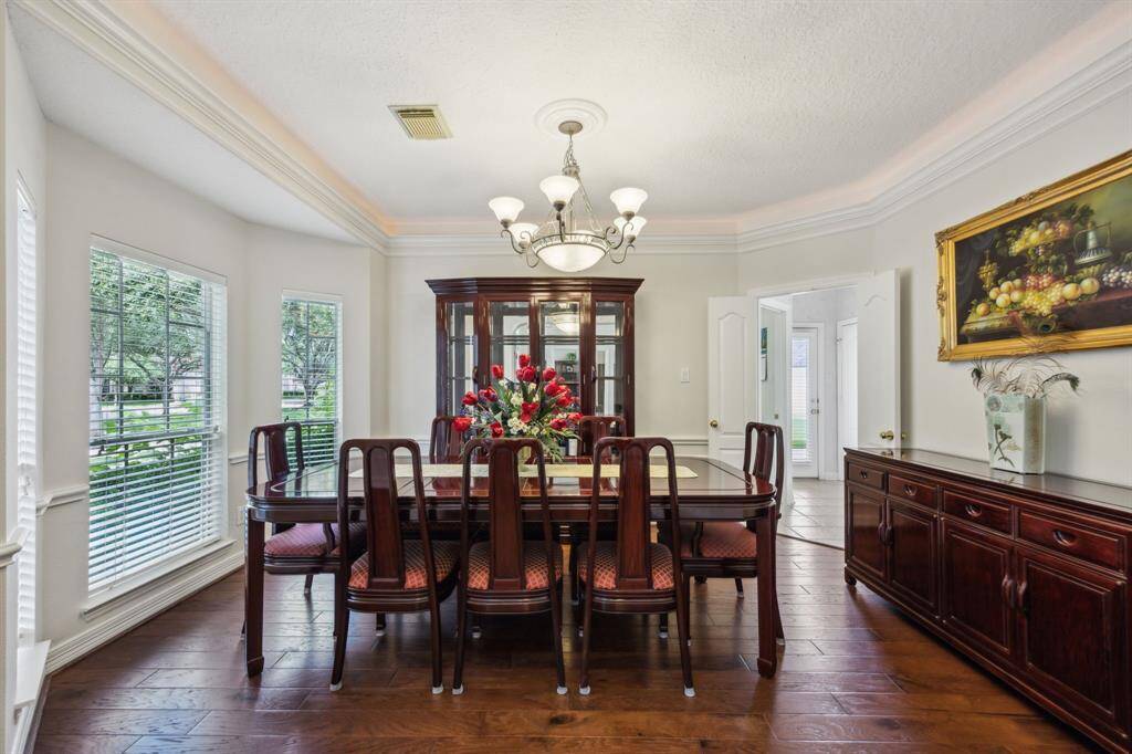 The formal dining room is a perfect blend of charm and sophistication, ideal for hosting memorable dinners and celebrations. Crown molding adds a touch of classic elegance, while the expansive bay window bathes the space in natural light and offers serene views of the front landscaping.