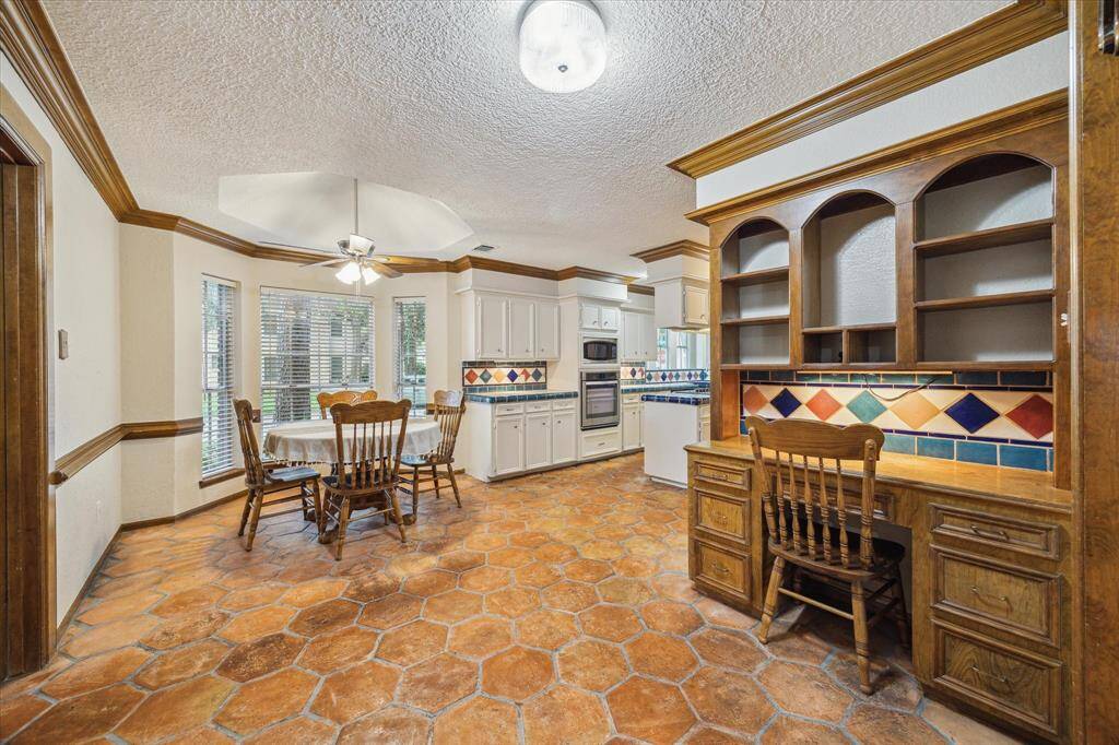 The large dining nook features saltillo tile flooring and a built-in wooden desk.