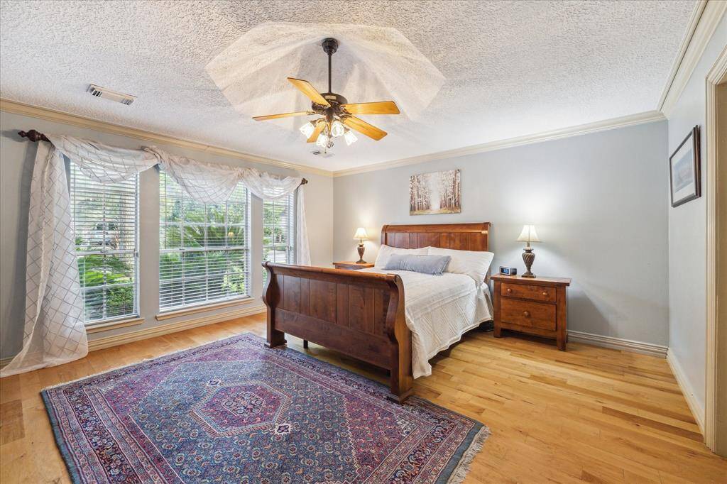 This inviting primary bedroom features custom hardwood floors and a large window for plenty of light.