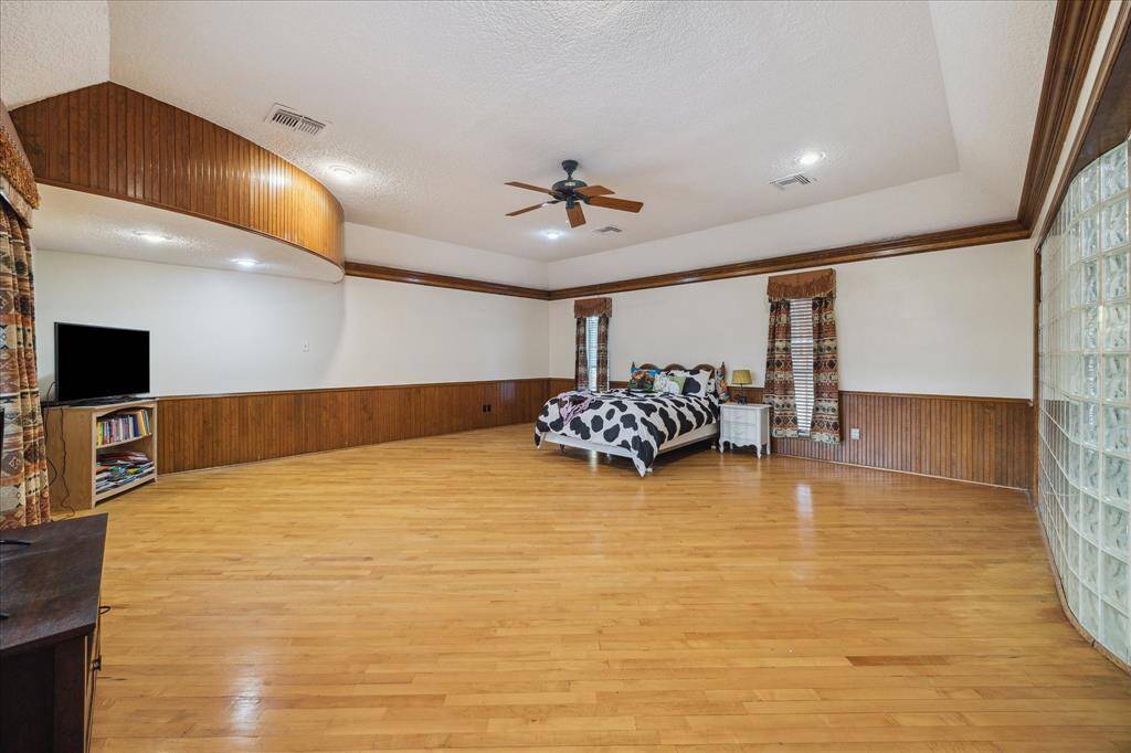 This spacious upstairs room can be utilized as primary bedroom or game room with ensuite bathroom with glass block shower.