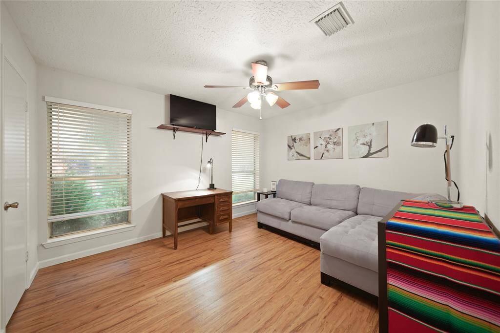 Located at the front of the home, this secondary bedroom offers picturesque views of the lush yard and vibrant flowering beds.