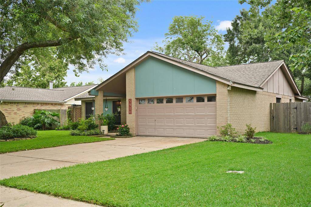 This single-story home features a two-car garage with an exterior brick facade located in a cozy suburban setting.