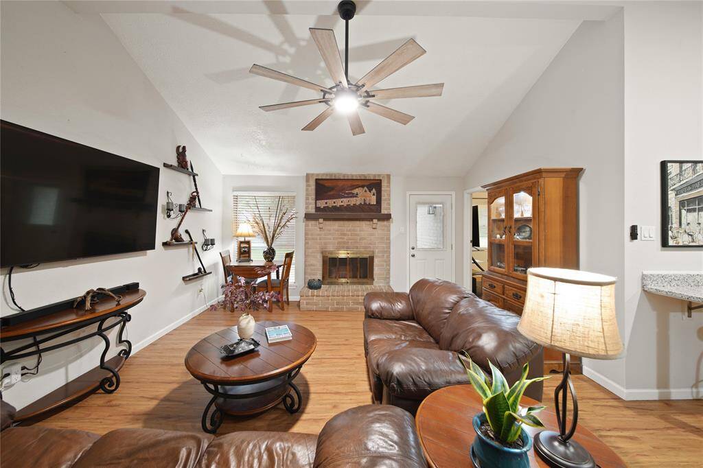 The warmth of the brick fireplace and elegant wood flooring make this living space a cozy retreat.